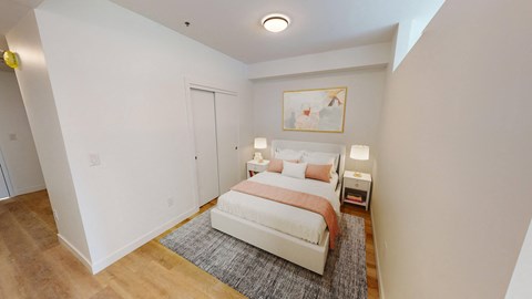 a bedroom with a white bed and a rug